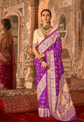 Woman wearing a dark violet Bandhej print silk blend saree with traditional cream accents