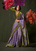 A modern violet satin crepe saree with geometric prints, draped to display the luxurious sheen and elegant fall.