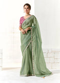 Dark sea green tissue and organza saree adorned with all-over sequin and embroidery work.