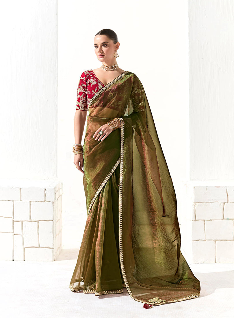 Dark olive green tissue and organza saree with sequin embroidery and traditional detailing.