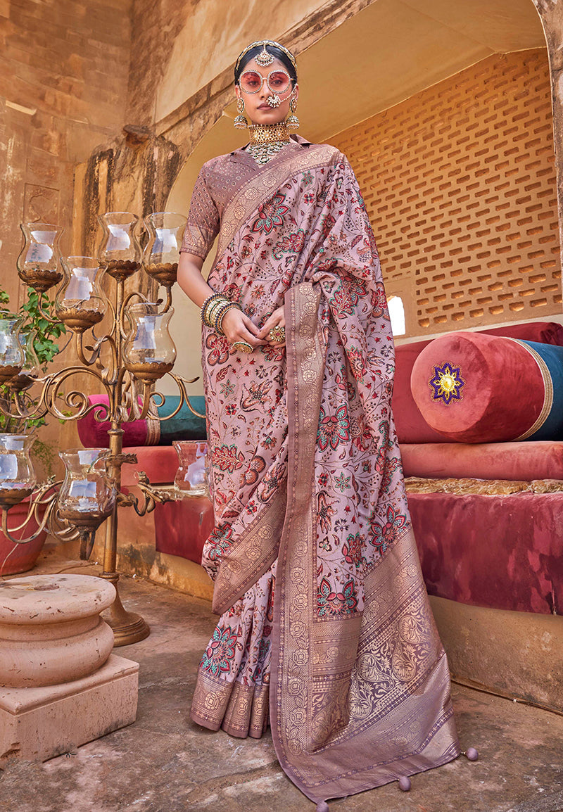 Dusty pink floral print silk blend saree with a woven border and decorative tassels.