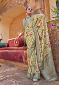 Light green silk blend saree with floral prints and a decorative tasseled pallu