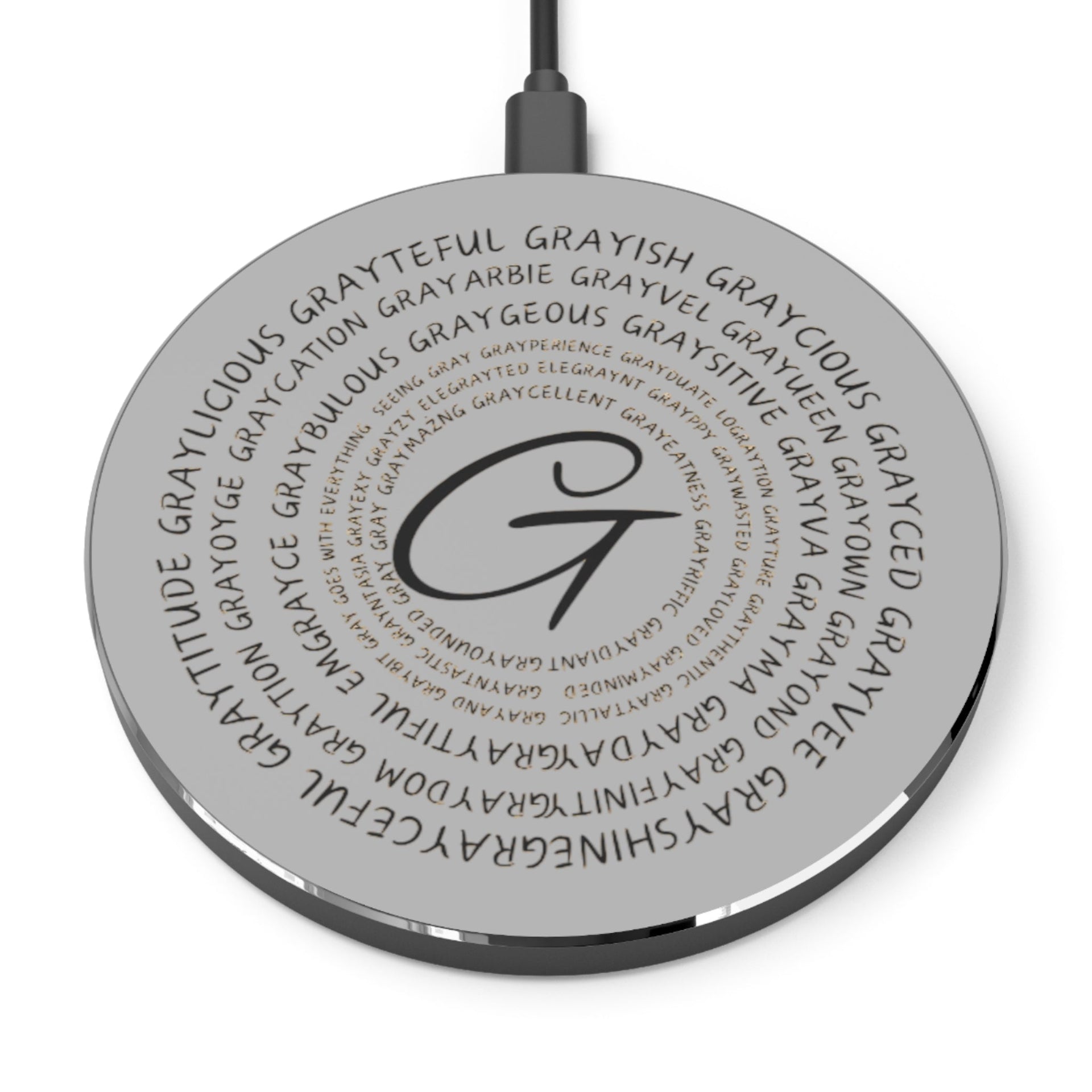 A sleek, minimalist wireless charger in black or silver finish on a modern desk.