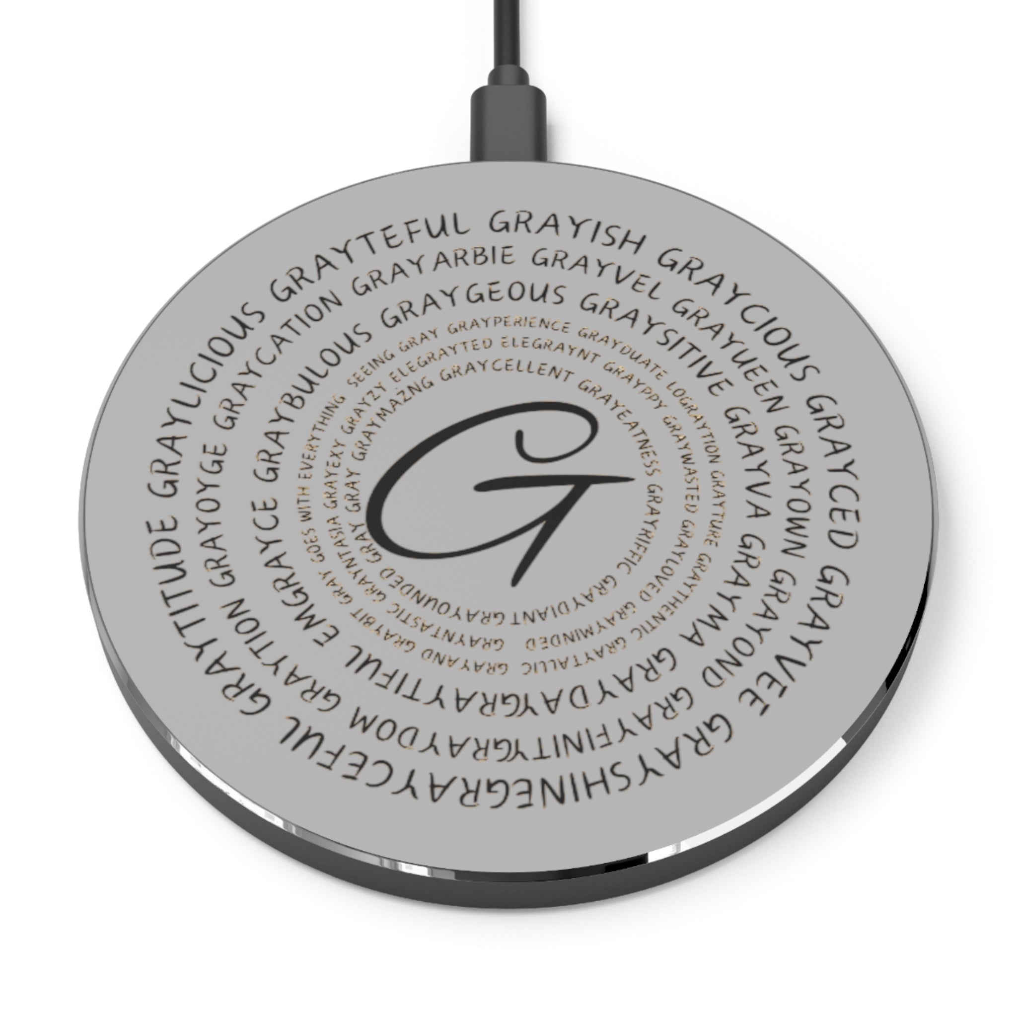 A sleek, minimalist wireless charger in black or silver finish on a modern desk.