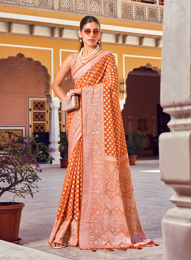 Orange and rust georgette saree with detailed ethnic weaving for a contemporary look.