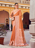 Orange and rust georgette saree with detailed ethnic weaving for a contemporary look.