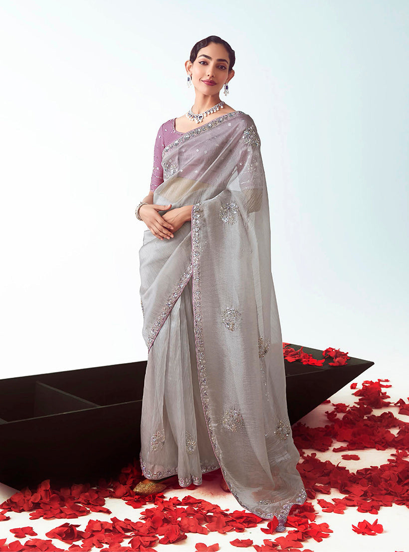 Grey ceremonial designer saree featuring detailed cut-work embroidery.