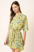 Woman wearing a floral tie-waist half sleeve mini dress in a cottagecore bohemian style