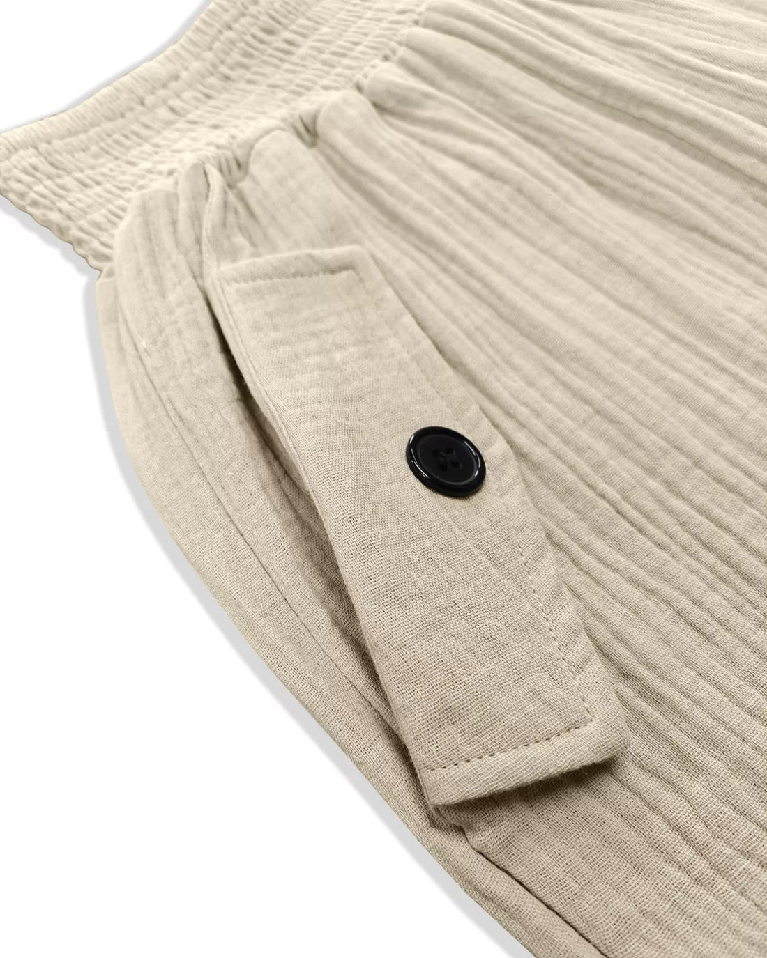 Close-up of a beige ribbed sweater with a black button on a white background