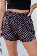Model wearing brown and black checkered high-waist elastic shorts