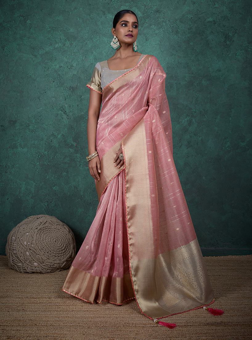 Model wearing a light pink linen blend saree with woven sequin work and an included matching blouse