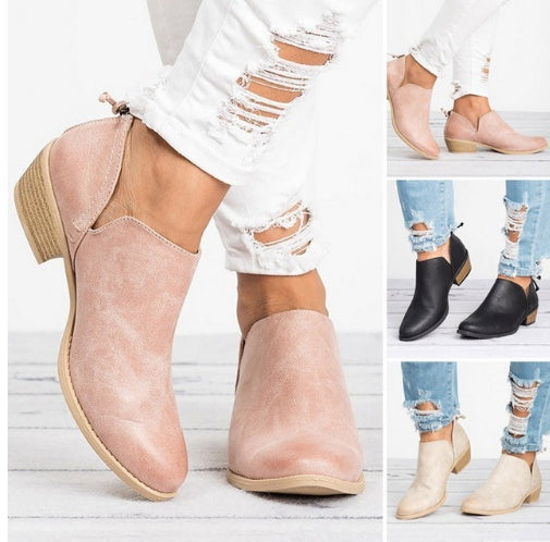A pair of women's retro ankle boots with a chunky heel worn with white distressed jeans.
