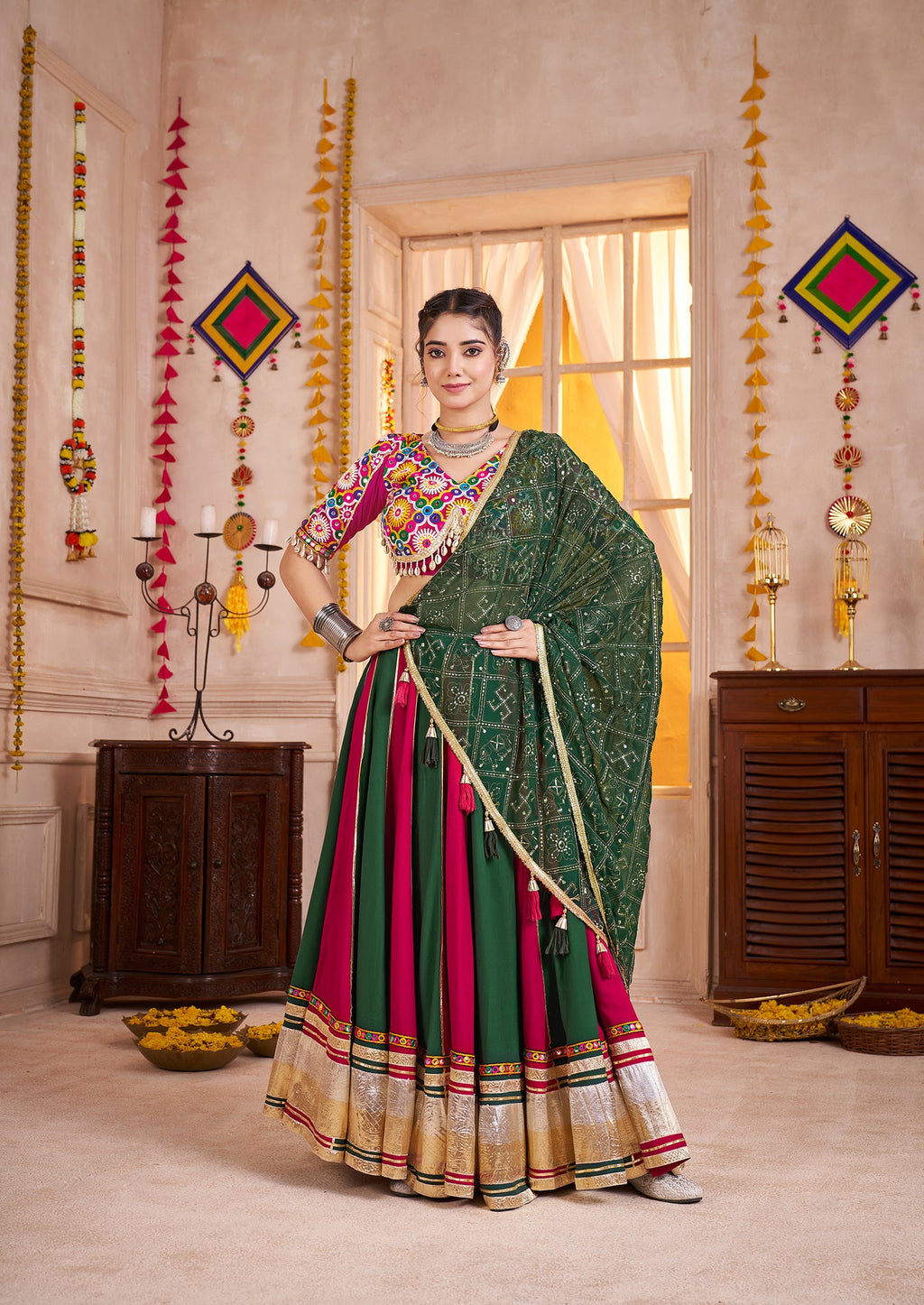 Woman wearing a colorful viscose cotton Navratri lehenga with traditional Kutchi mirror work choli in green, magenta, and gold.