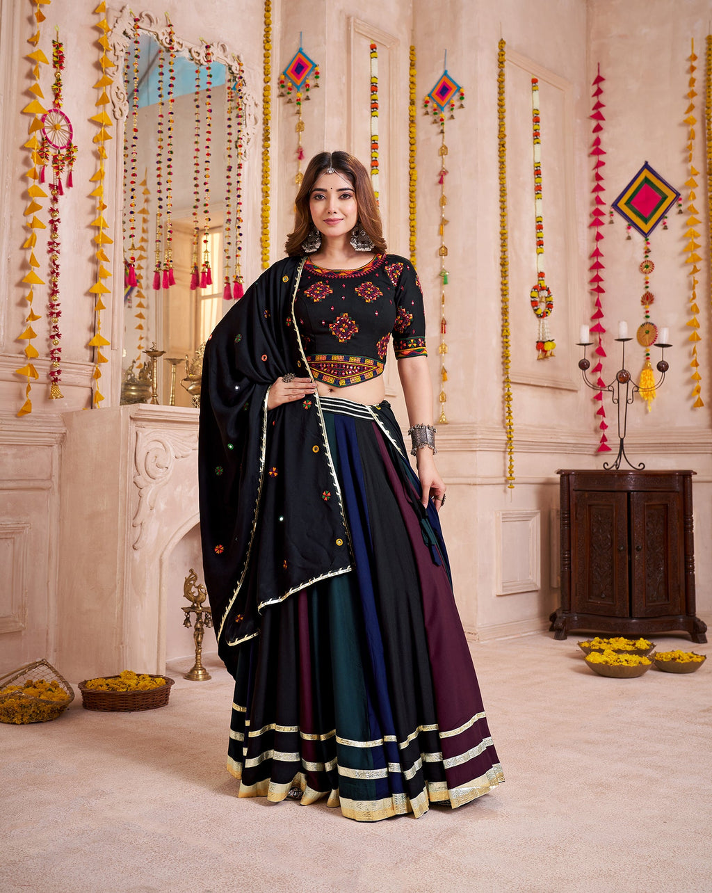 Woman wearing a multi-color viscose cotton Navratri lehenga choli with traditional hand mirror work
