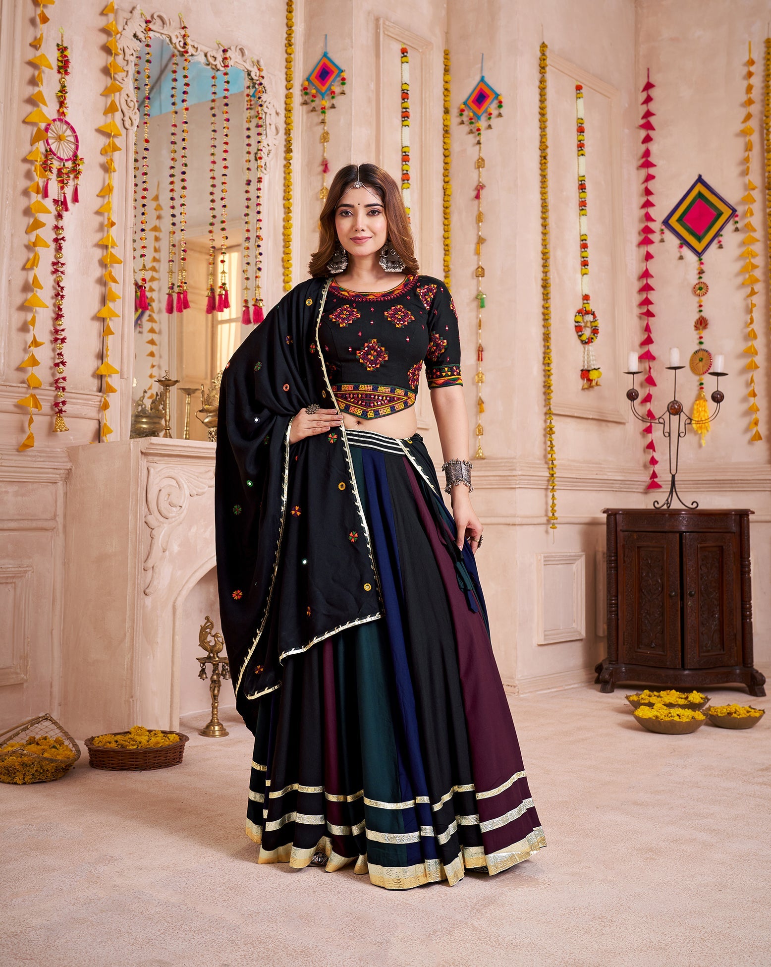 Woman wearing a multi-color viscose cotton Navratri lehenga choli with traditional hand mirror work