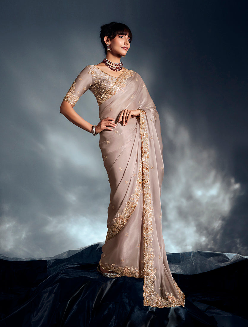Ivory tissue organza saree decorated with exquisite moti, cutdana, and sequin embroidery.