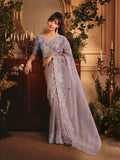 Light lilac tissue organza saree with all-over butta work and a heavy stone-embellished border
