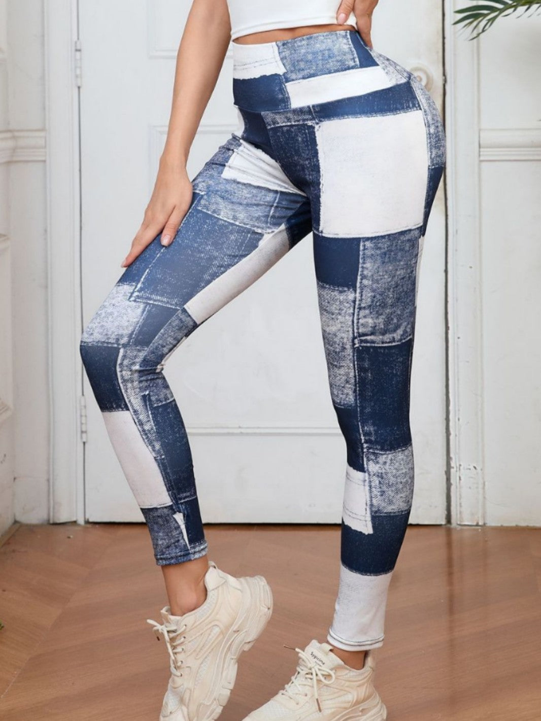 Woman wearing high-waisted denim-look plaid peach print fitness yoga pants in blue-white