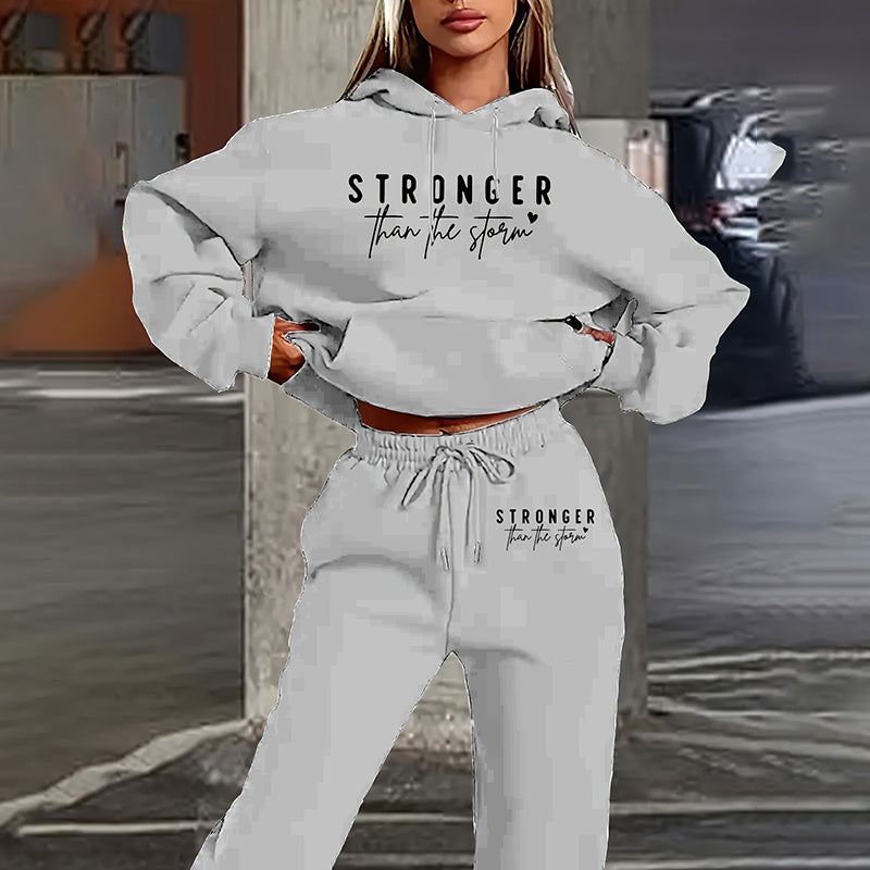 Woman wearing a gray 2-piece set with long-sleeve hoodie and matching joggers with letter print.