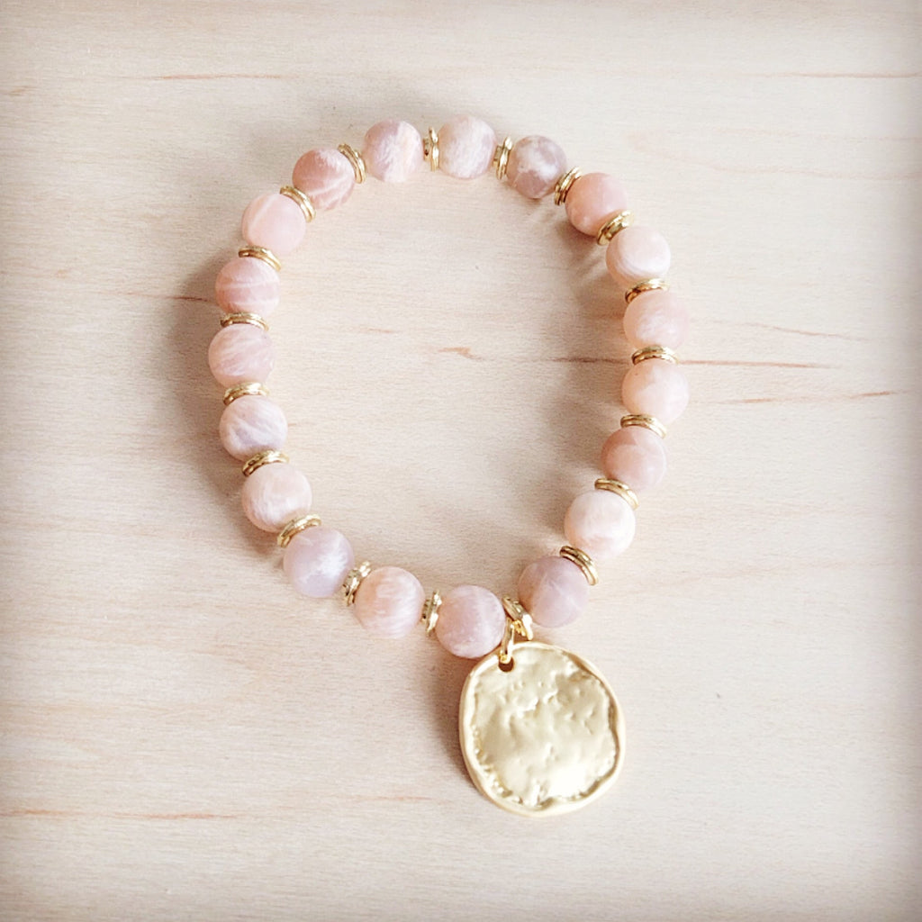 Frosted sunstone bead stretch bracelet with a decorative matte gold-tone charm