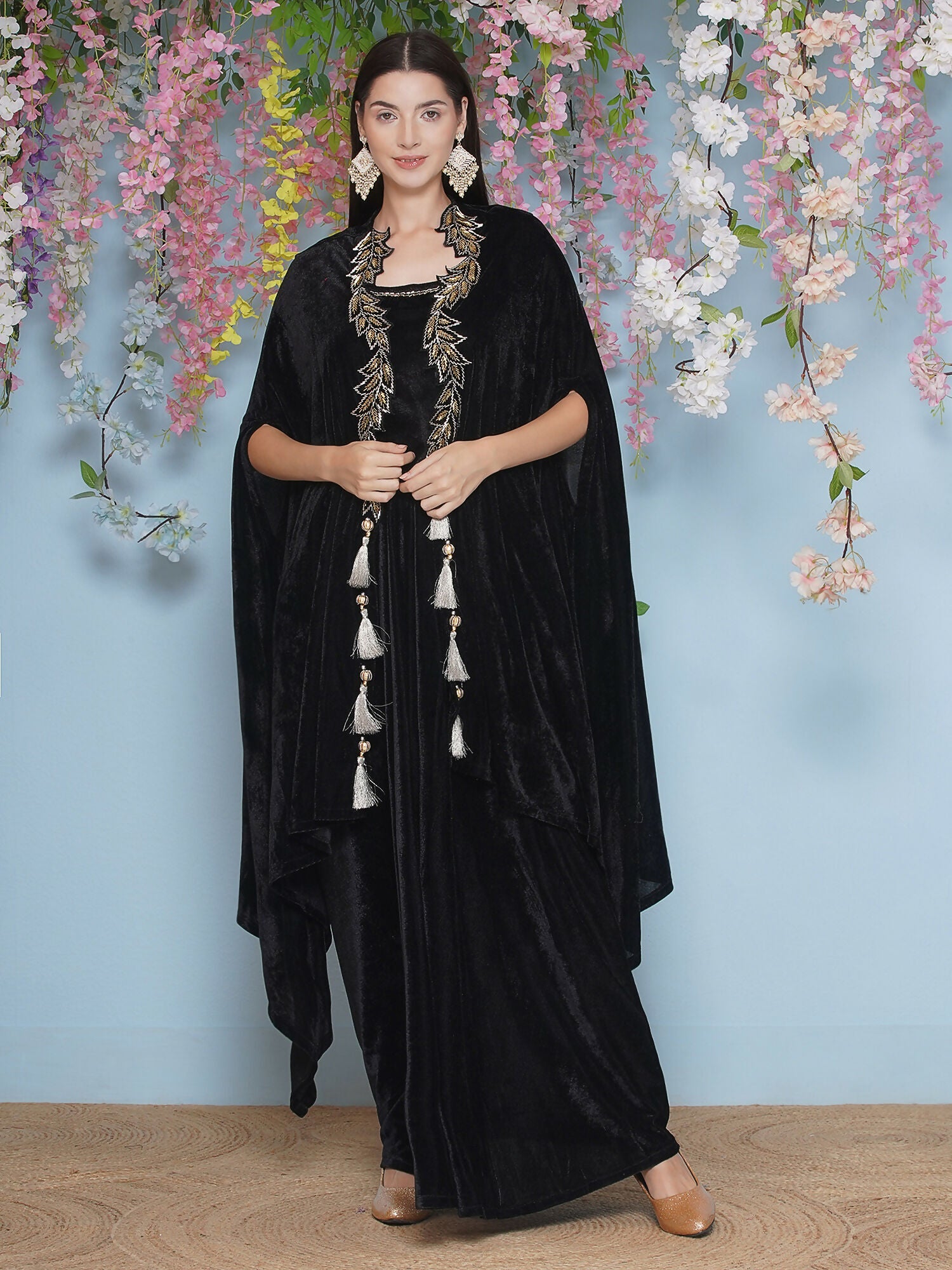Model wearing a black velvet hand-embellished cape with matching inner and skirt