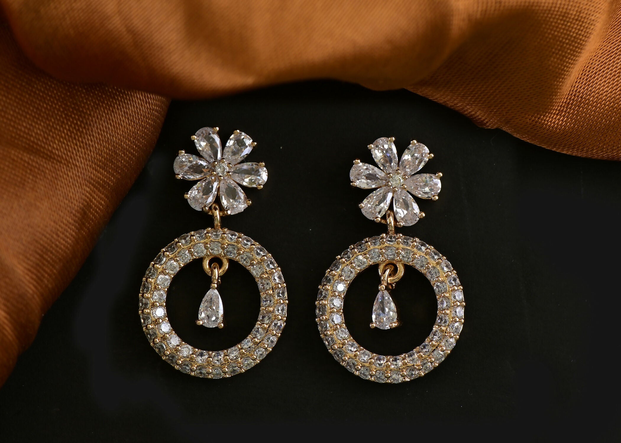 Elegant golden white brass earrings with American Diamond detailing.