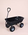 Heavy duty black and grey garden dump cart with 10-inch pneumatic tires on a grass surface
