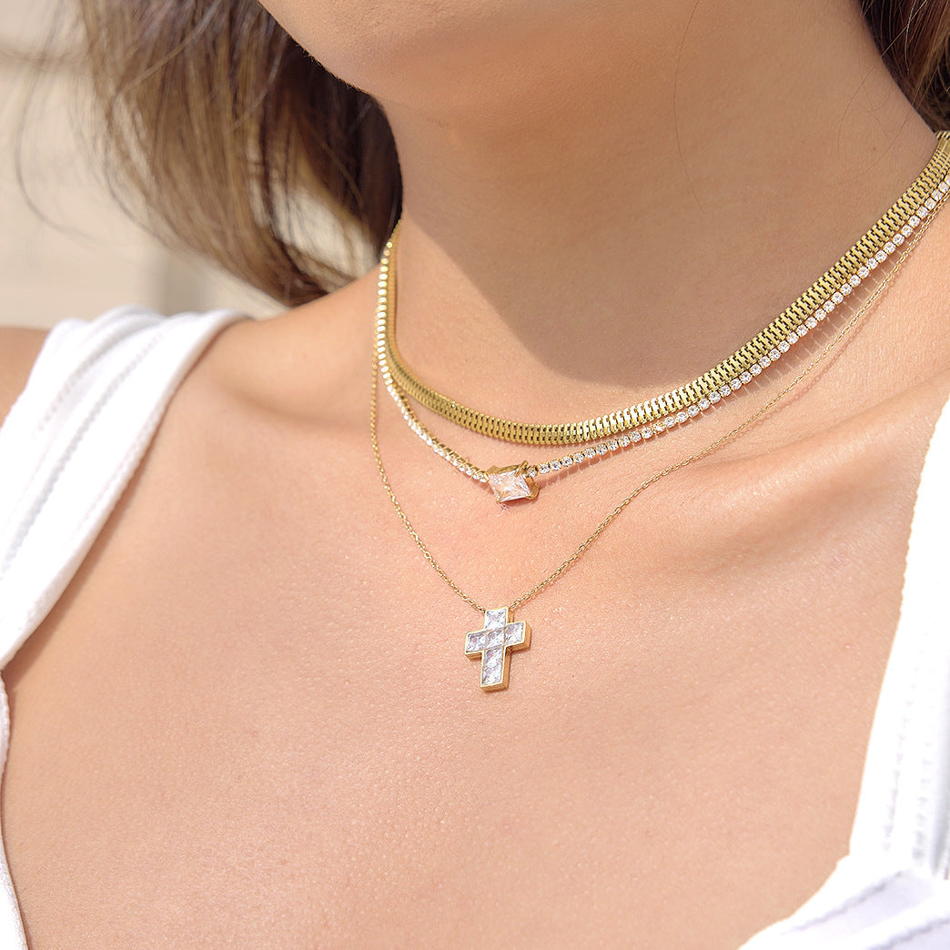 A gleaming stainless steel cross pendant featuring inset zircon stones.