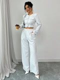 A woman wearing a stylish tweed jacket with pearl buttons paired with matching trousers.