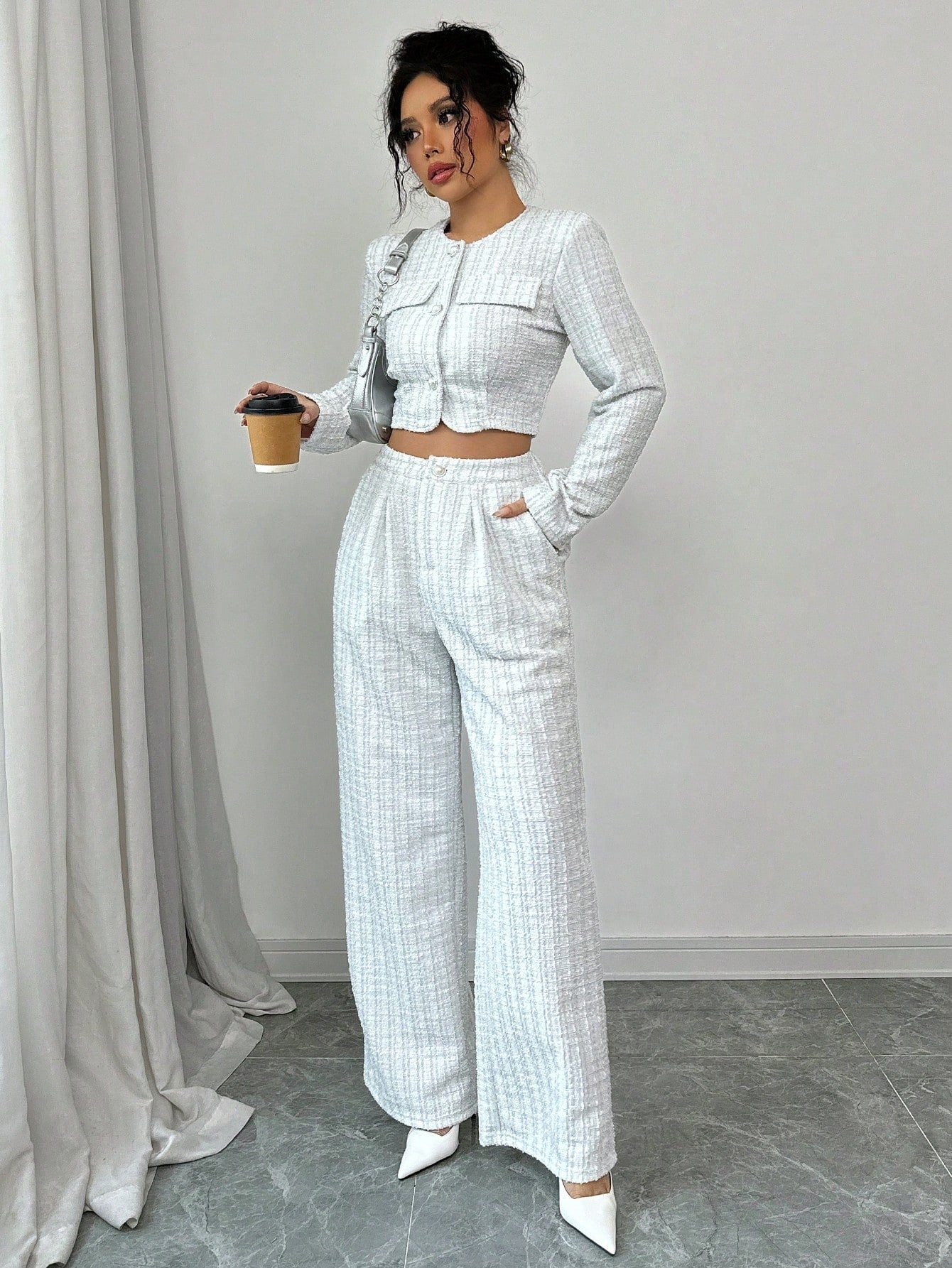 A woman wearing a stylish tweed jacket with pearl buttons paired with matching trousers.