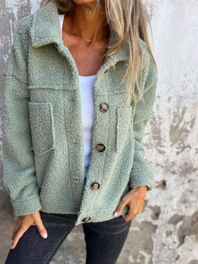 Close up of a fuzzy button-up jacket for women with drop shoulders and side pockets.
