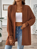 Model wearing a rust-colored long sleeve open front ribbed knit cardigan