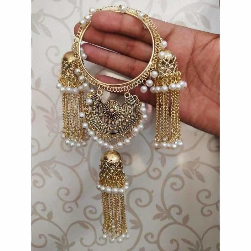 Gold-tone bracelet featuring white pearl embellishments and dangling jhumka chains