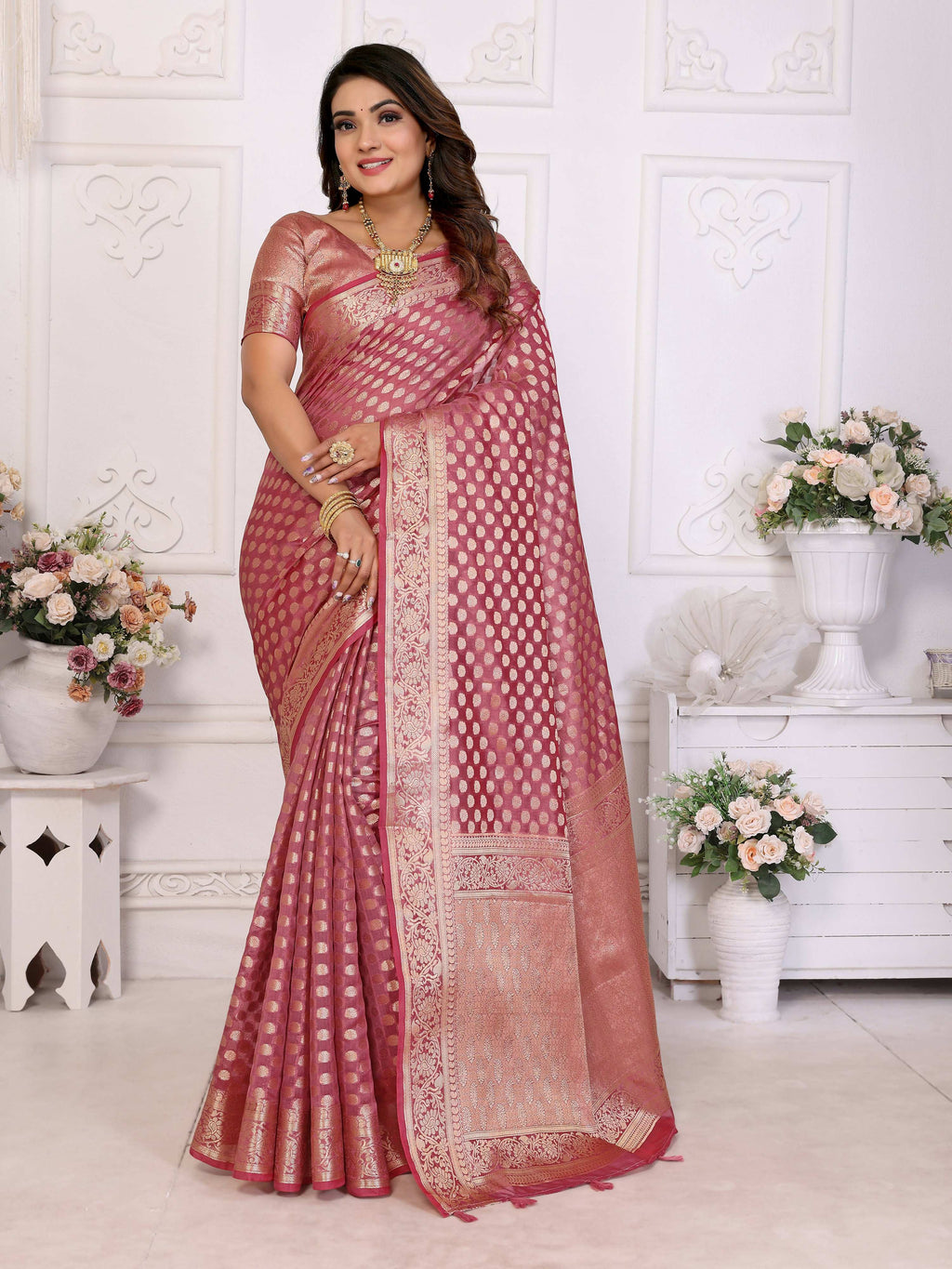 A soft Light Pink Organza Silk saree with delicate weaving patterns.