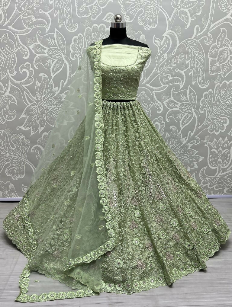 Pista green bridal net lehenga with mirror and diamond embellishments.