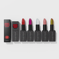 Collection of five Rocky Horror Show lipsticks with black glitter packaging, including shades of red, pink, silver-white, dusty rose, and bronze-gold.