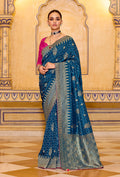 Elegant teal blue faux crepe silk saree with intricate zari weaving work and matching unstitched blouse