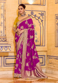 Magenta faux crepe silk saree with intricate gold Zari weaving work draped elegantly.
