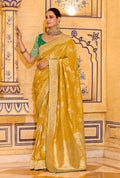 Mustard faux crepe silk saree with intricate gold Zari weaving work draped elegantly