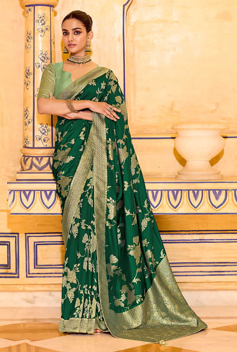A dark green faux crepe silk saree with detailed zari weaving patterns