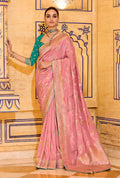 A baby pink faux crepe silk saree for children featuring intricate gold zari weaving patterns.