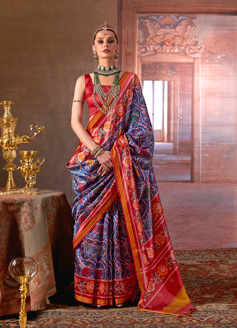 Navy blue silk blend saree featuring traditional Patola print with an included red blouse.