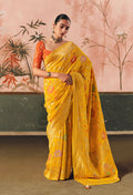 Traditional yellow Bandhej saree in faux khadi georgette with intricate weaving patterns