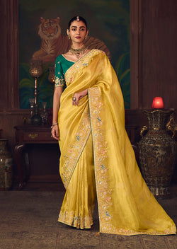 Yellow silk blend wedding saree with zari weaving and contrasting teal stone-work blouse