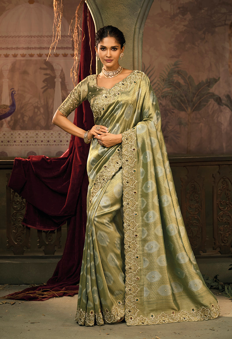 Woman wearing an olive green silk blend saree with intricate jari and cut-dana embroidery