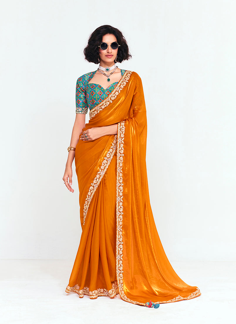 Orange fancy fabric saree featuring sequin work and traditional embroidery.