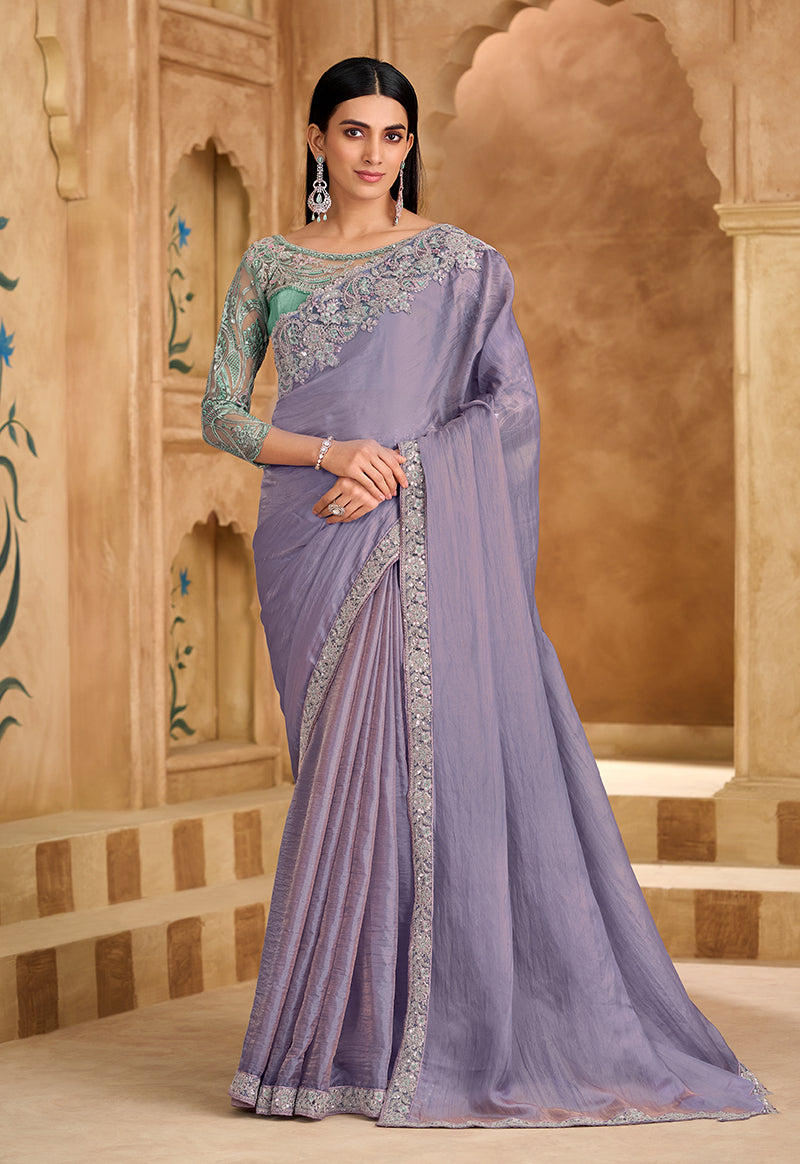 Lavender faux chiffon saree with intricate border embroidery and unstitched blouse piece.