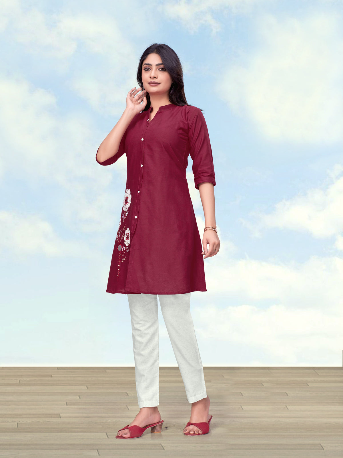 Woman wearing a maroon cotton flex kurta set with intricate embroidery on the neckline.