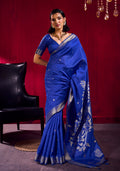 Royal blue satin linen silk saree with gold floral motifs and temple-patterned zari border.