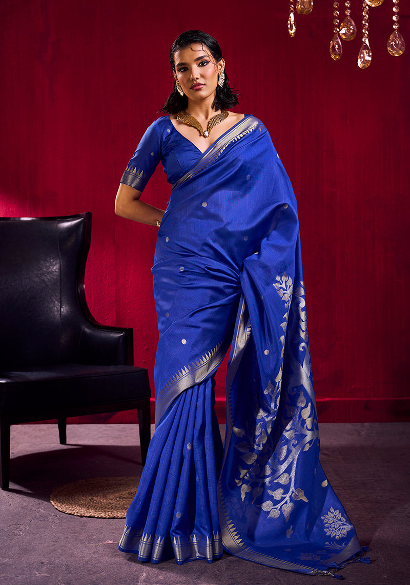 Royal blue satin linen silk saree with gold floral motifs and temple-patterned zari border.